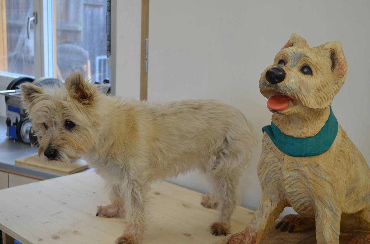 Cairn Terrier neben der Skulptur